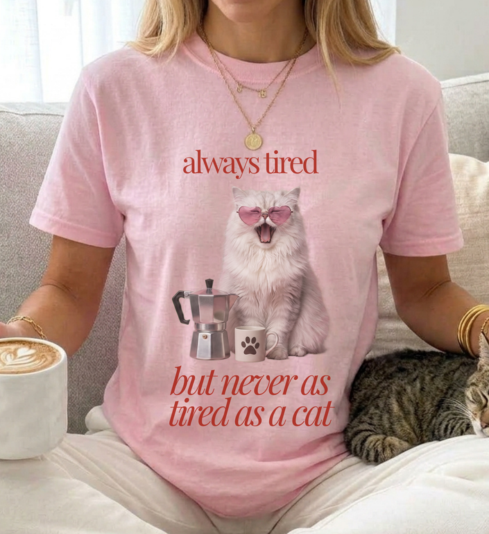 young woman is wearing a cute cat shirt with the quote always tired bu  in minimal typography old money stylet never as tired as a cat