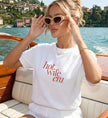 Ästhetisches JGA und Flitterwochen Outfit auf einem edlen Holzboot auf dem Wasser mit modernem Hot Wife Era Print und Retro Sonnenbrille
