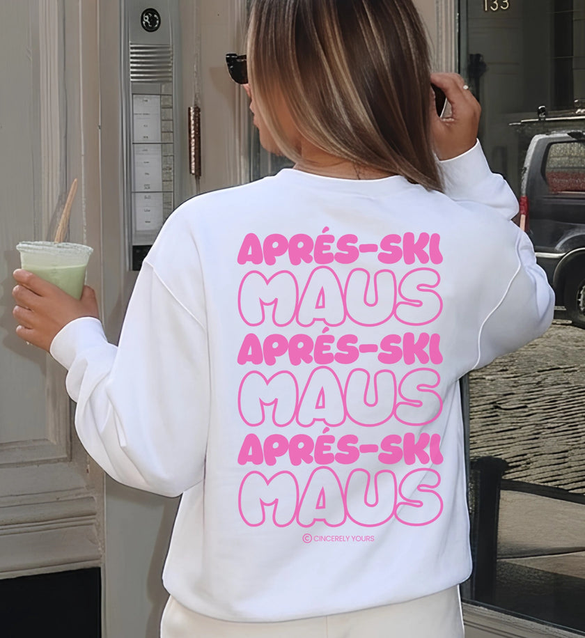 Rückansicht eines weißen Cincerely Yours Sweatshirts mit markantem Apres Ski Maus Backprint in pinker Bubble-Typografie, die Frau hält einen grünen Sommerdrink.