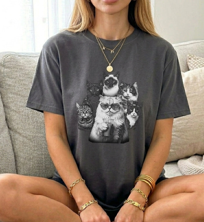 Graues Cincerely Yours T-Shirt mit schwarz-weißem Bootleg-Motiv einer Katzen-Gang, Katze mit Herz-Sonnenbrille und Trinkbecher, lockere Passform, sitzende Person, hochwertiger Retro-Grafikdruck.