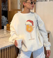 Weißes Langarm-Sweatshirt der Marke Cincerely Yours mit weihnachtlichem Cocktail-Print, trägt Weihnachtsmannmütze, perfekt kombiniert zu heller Hose für einen modernen Party-Look.