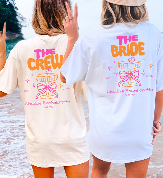 Zwei Frauen am Strand in personalisierten Coquette Bachelorette Shirts von Cincerely Yours mit Neon Cocktail-Design, rosa Schleife und den Aufschriften The Crew und The Bride für einen JGA.