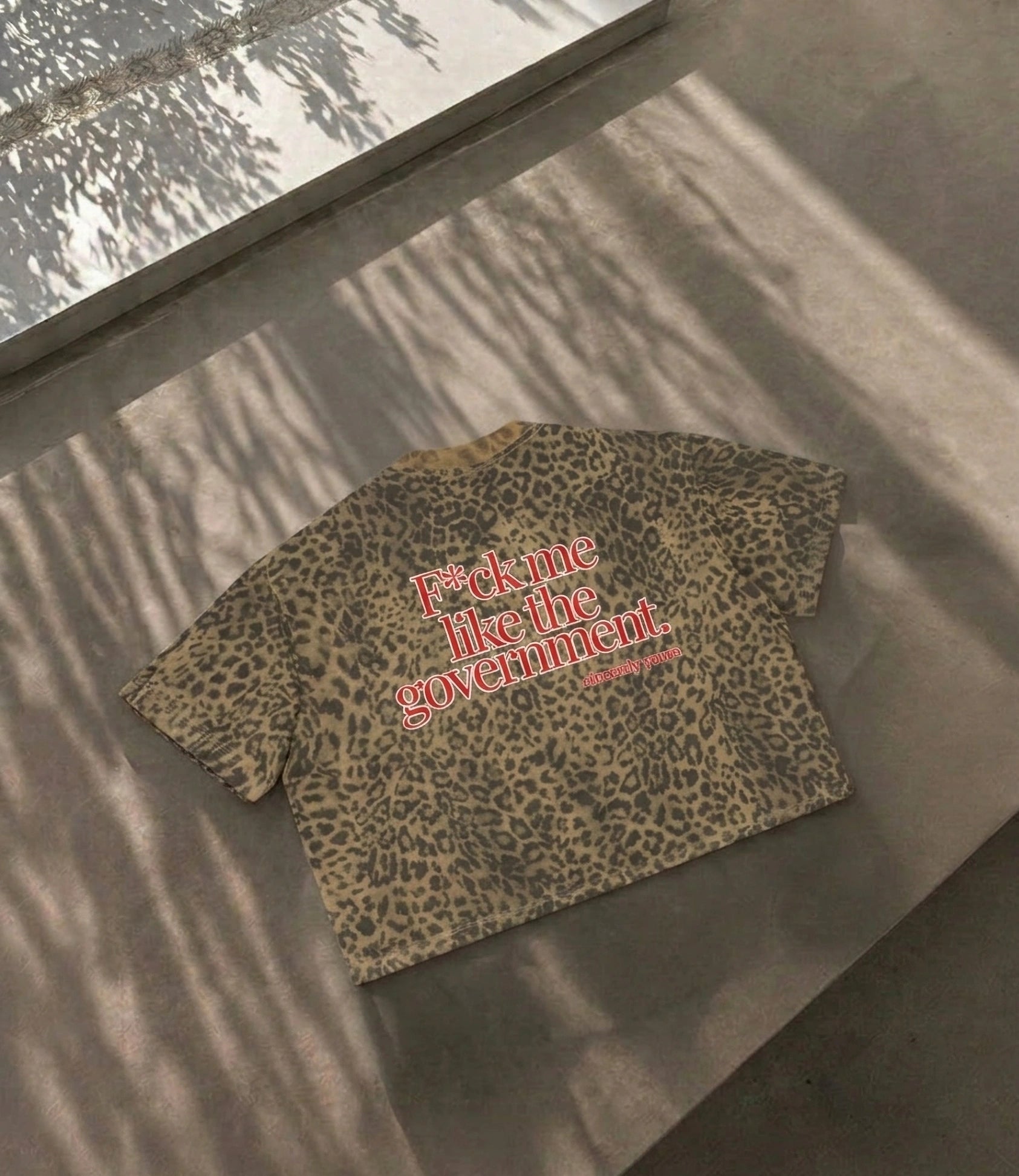 Nahaufnahme des Cincerely Yours Unisex Boxy T-Shirts mit Leopard Print und dem provokanten Spruch Fuck Me Like The Government in Schwarz.