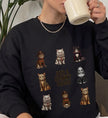 Eine Person trägt ein schwarzes Cincerely Yours Sweatshirt mit Just a Spawky Squad Grafik aus gruseligen Katzen-Charakteren im Horror-Stil.