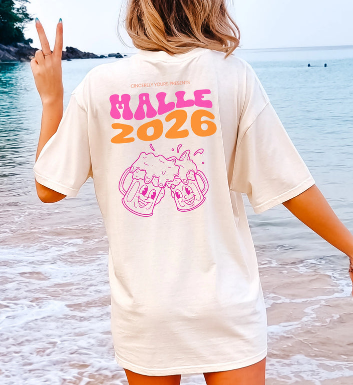 Cincerely Yours Malle 2026 T-Shirt mit Backprint: Weißes Oversized-Shirt mit pink-orangefarbenem Malle-Schriftzug und lachenden Bierkrügen, getragen am Strand.