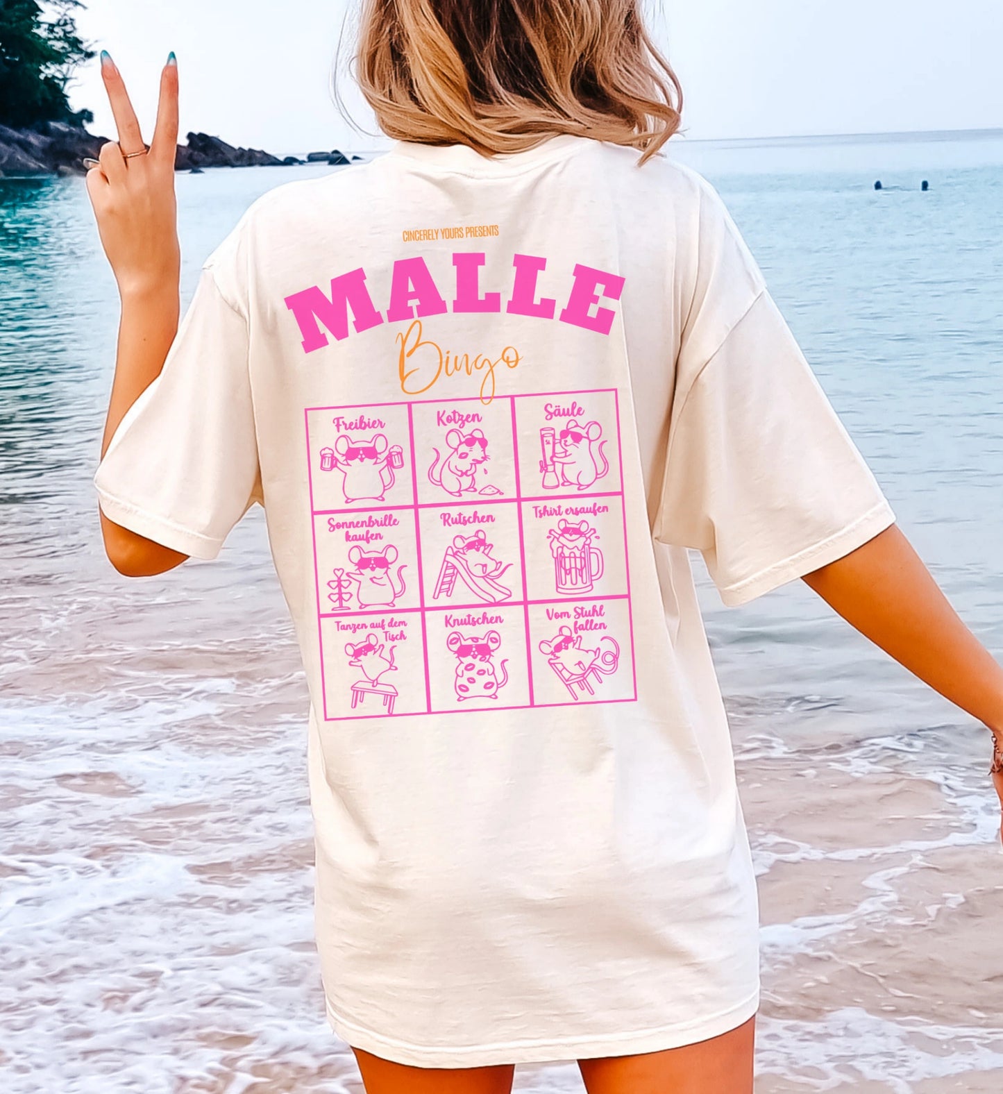 Cincerely Yours Mallemaus Shirt in Beige mit pinkem Malle Bingo Aufdruck auf dem Rücken, getragen von einer Frau am Strand – ideales Malle Party Shirt für den Urlaub.