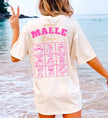Cincerely Yours Mallemaus Shirt in Beige mit pinkem Malle Bingo Aufdruck auf dem Rücken, getragen von einer Frau am Strand – ideales Malle Party Shirt für den Urlaub.