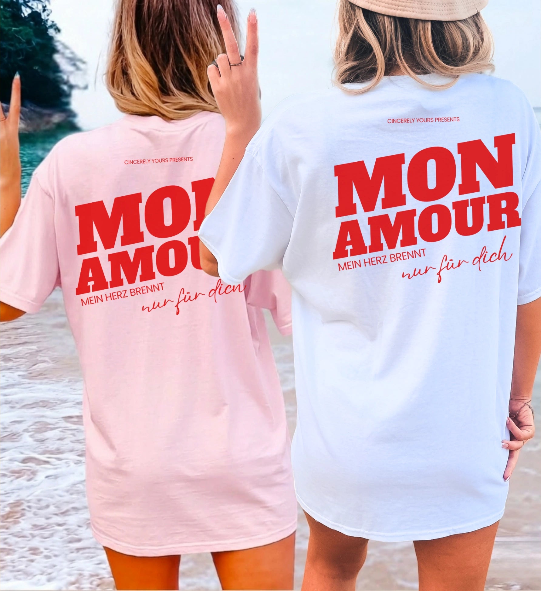 Zwei Frauen am Strand in der Rückansicht mit dem Cincerely Yours Malle Party Shirt in Pink und Weiß, bedruckt mit dem roten Backprint 'Mon Amour - Mein Herz brennt nur für dich'.