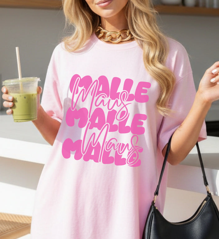Eine Frau trägt ein hellrosa Oversized T-Shirt von Cincerely Yours mit pinkem Mallemaus Bubble-Font Schriftzug, kombiniert mit einer goldenen Kette.