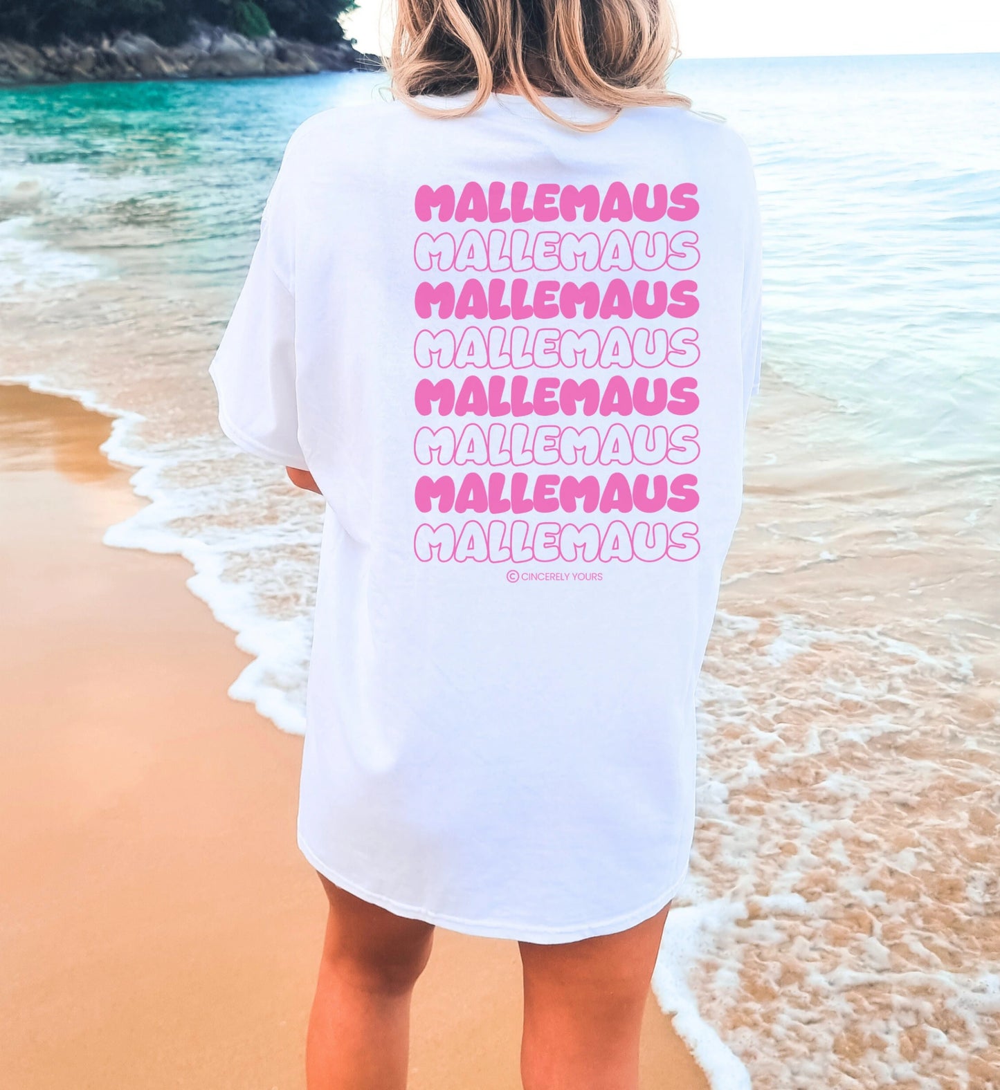 Weißes Oversize Mallemaus Shirt von Cincerely Yours mit pinkem Malle Maus T-Shirt Backprint, Motiv Mallemaus pink in der Rückenansicht am Strand.
