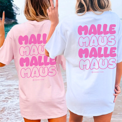 Zwei Frauen am Strand in Cincerely Yours Mallemaus Shirts in Pink und Weiß mit großem pinkem Malle Maus Rückenprint in Retro-Schrift.