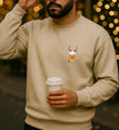 Mann trägt beigefarbenes Merry Drunkmas Sweatshirt mit kleinem Rentier-Bierkrug-Brustprint und Coffee Cup in stimmungsvoller Beleuchtung.