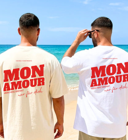 Zwei Männer am Strand in Cincerely Yours Oversized T-Shirts in Weiß und Beige mit rotem 'Mon Amour - Mein Herz brennt nur für dich' Backprint.