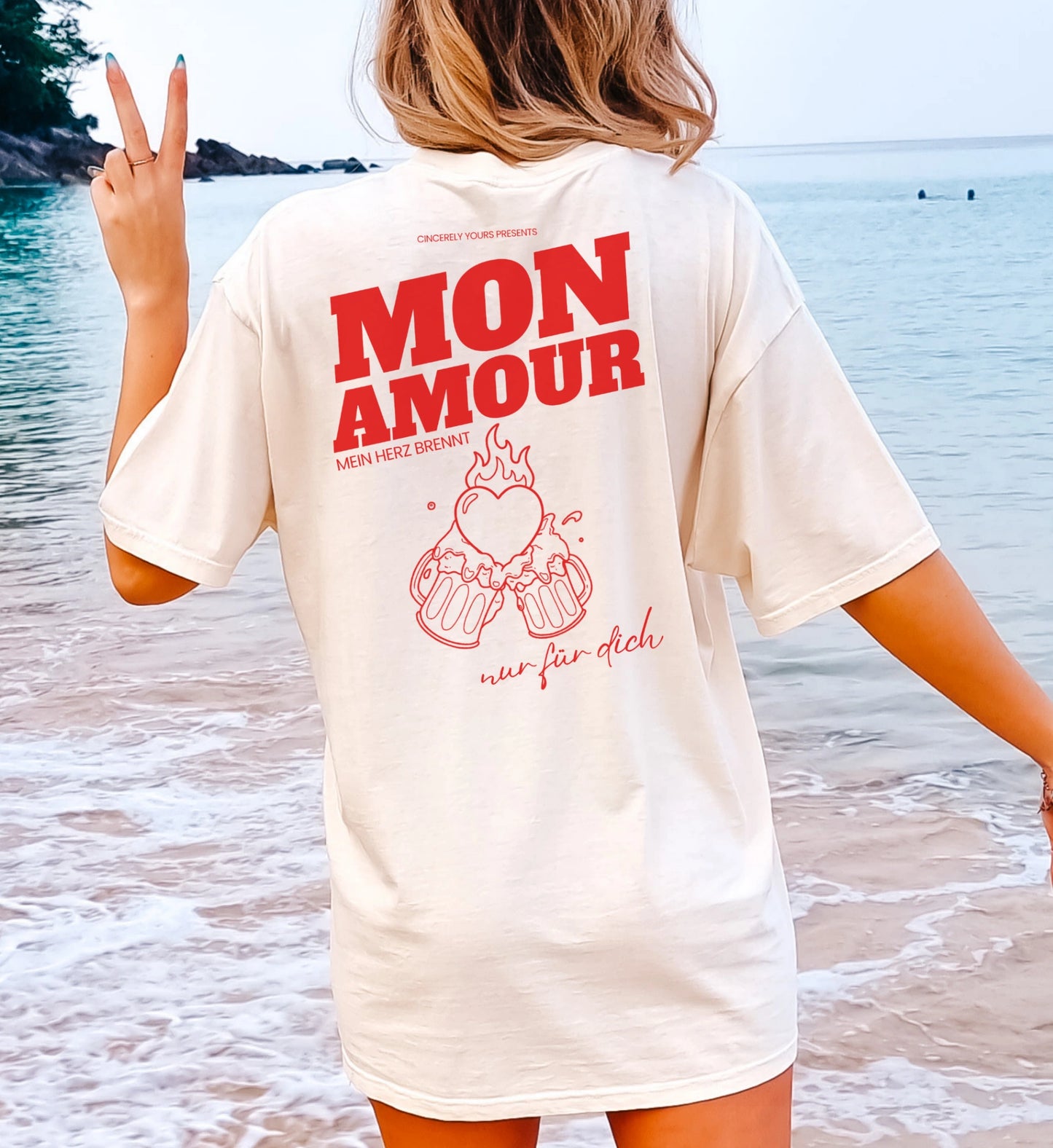 Cincerely Yours Mon Amour T-Shirt in Cremeweiß, Malle Party Shirt mit rotem Backprint 'Mein Herz brennt nur für dich' und Bierkrug-Grafik, Rückansicht am Strand.