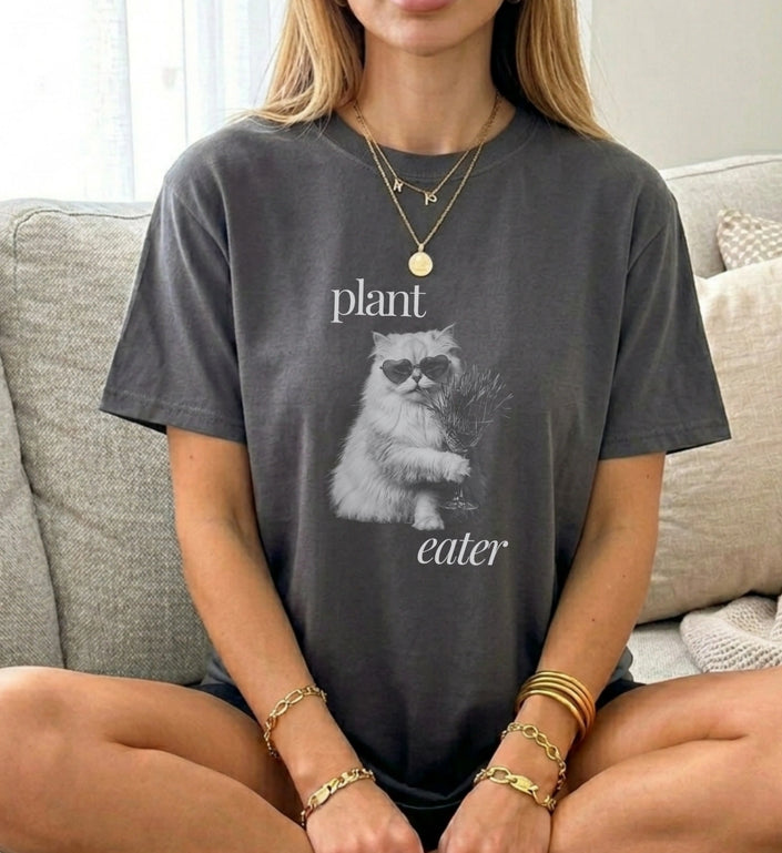 Frau sitzend im grauen Vintage Washed Oversize T-Shirt mit Plant Eater Katzen-Grafik und Sonnenbrille von Cincerely Yours.