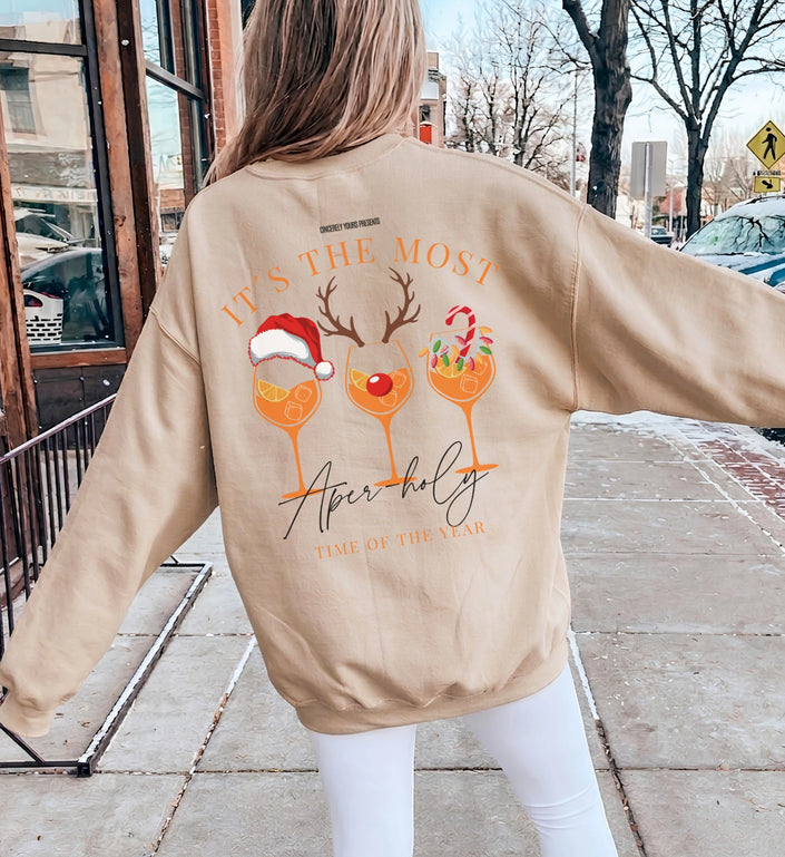 Rückenansicht eines beigen Sweatshirts mit detailreichem Weihnachts-Cocktail-Grafik-Aufdruck, festlichem Rentiergeweih und weihnachtlichem Schriftzug auf der Rückseite.