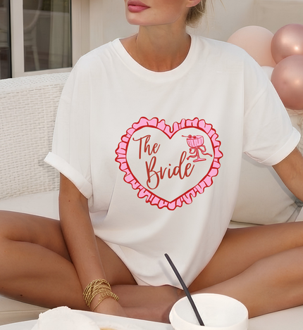 custom the bride shirt, coquette heart bride tee, personalized future mrs tee, cocktail bachelorette shirt, pink ruffled heart tshirt, getting ready bridal outfit, coquette bridal graphic tee, custom name bride to be top, martini glass bride shirt, aesthetic engagement gift, trendy oversized bride tee, girly bachelorette party top, custom mrs last name shirt