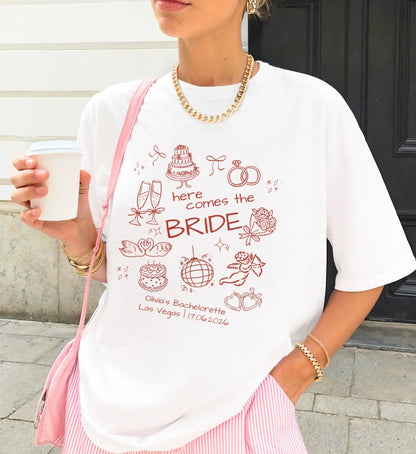 Weißes oversized T-Shirt für die Braut mit roten handgezeichneten Hochzeits-Doodles und Personalisierung für den Junggesellinnenabschied.