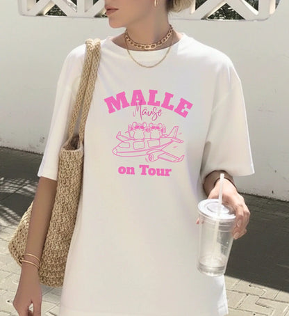 Weißes Oversized T-Shirt für Damen mit pinkem 'Malle Mäuse on Tour' Aufdruck und lustiger Mäuse-Illustration auf einem Flugzeug.