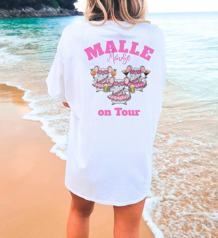Weißes Oversized T-Shirt für Damen mit pinkem 'Malle Mäuse on Tour' Aufdruck, Illustration von drei Mäusen mit Drinks und Tutus am Strand.