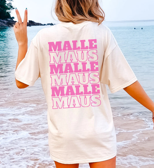 Oversized T-Shirt in Cremeweiß mit pinkem Malle Maus Rückenprint, getragen von einer Frau am Strand mit Peace-Zeichen.