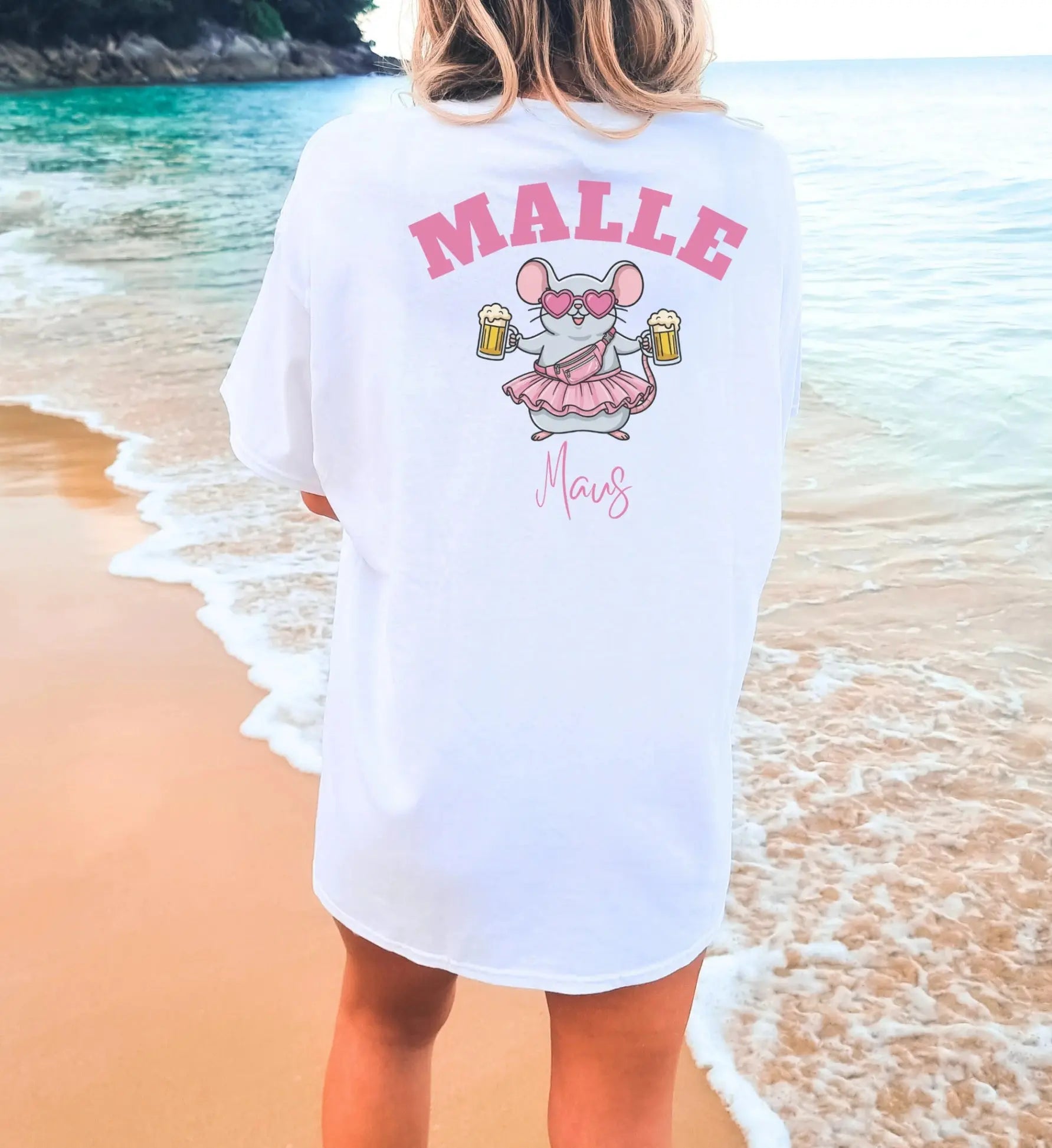 Weißes Oversize T-Shirt für Damen mit 'Malle Maus' Print auf dem Rücken, eine illustrierte Maus mit Bierkrügen, Herz-Sonnenbrille und rosa Rock vor einer Strandkulisse.