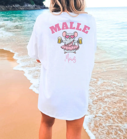 Weißes Oversize T-Shirt für Damen mit 'Malle Maus' Print auf dem Rücken, eine illustrierte Maus mit Bierkrügen, Herz-Sonnenbrille und rosa Rock vor einer Strandkulisse.