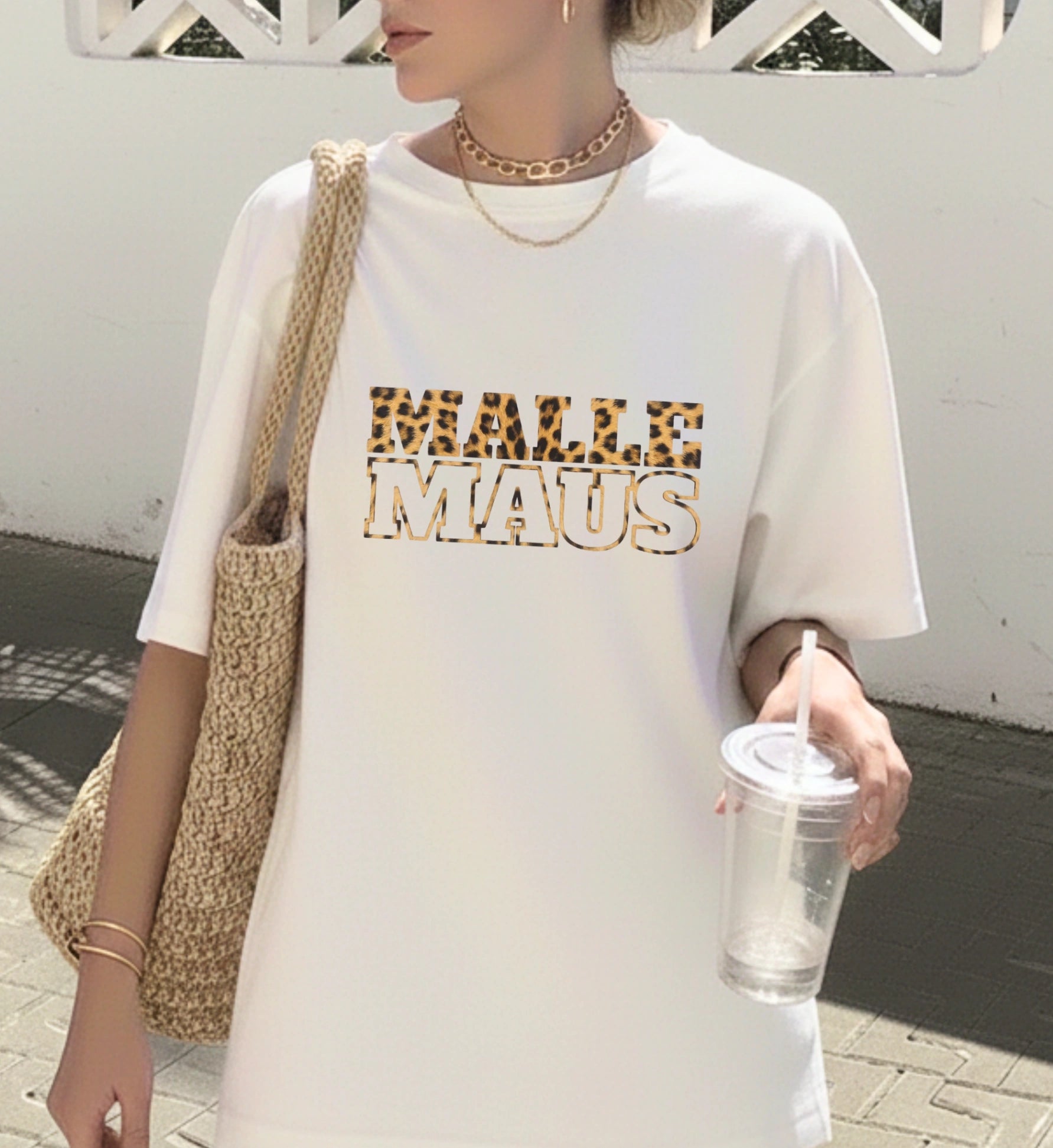 Weißes Malle Maus T-Shirt für Damen mit Leoparden-Muster Text-Print von Cincerely Yours, kombiniert mit einer Strohtasche im sommerlichen Lifestyle-Look.