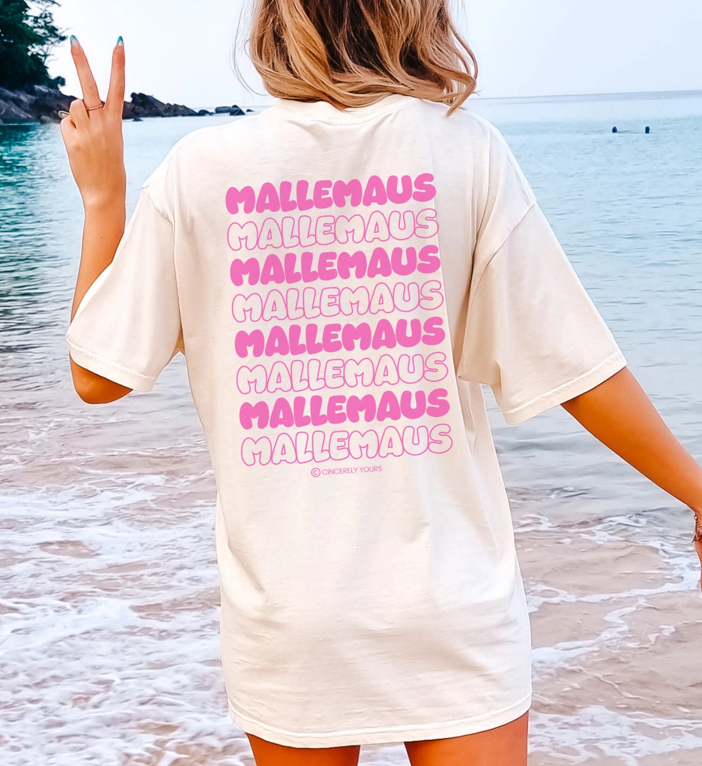 Oversized Mallemaus T-Shirt von Cincerely Yours in Off-White mit pinkem Backprint-Schriftzug, Rückansicht am Strand.