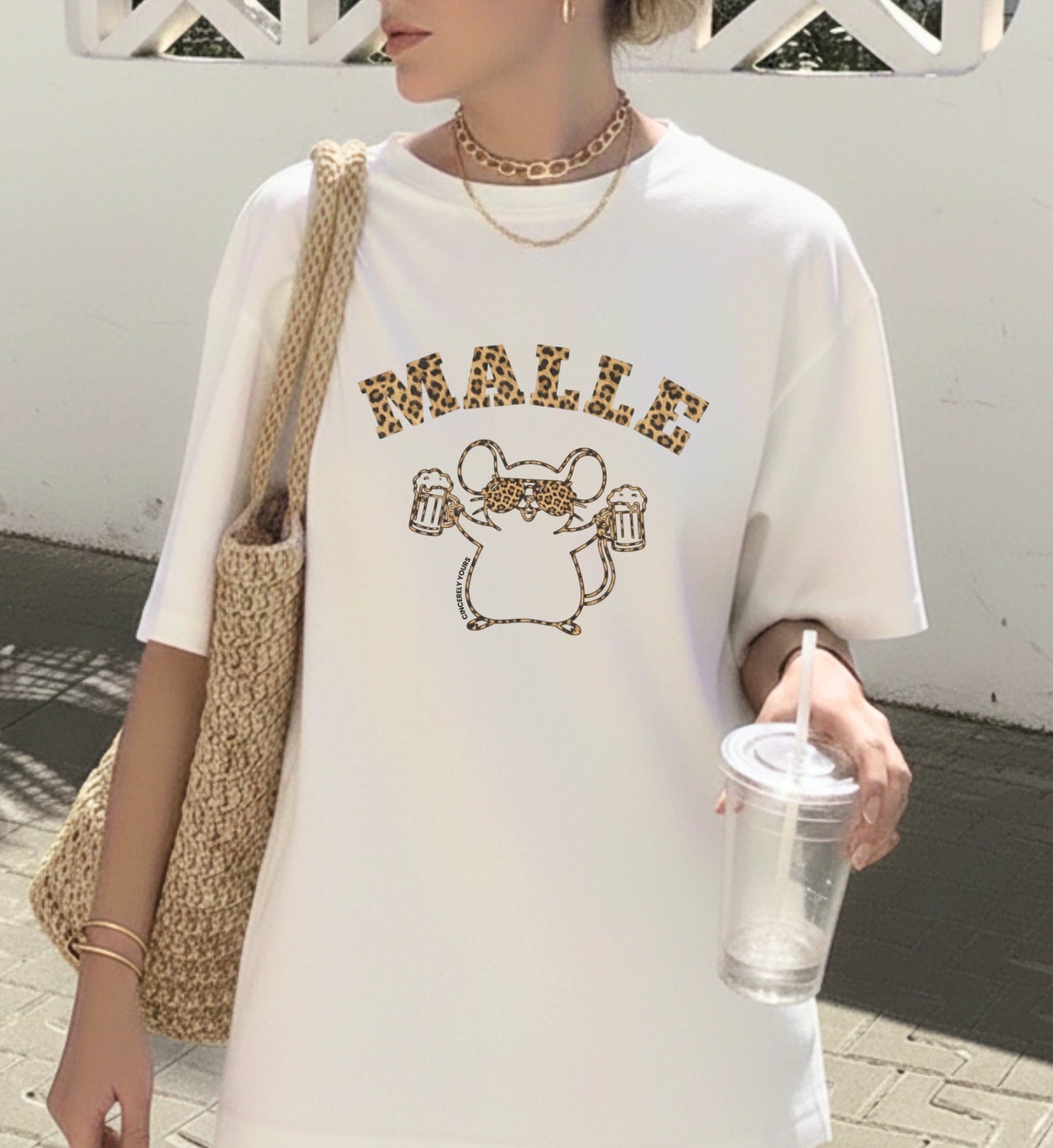 Frau trägt ein weißes Mallemaus T-Shirt von Cincerely Yours mit Leopard-Schriftzug Malle und einer Maus mit Sonnenbrille und Bierkrügen – ideales Party Shirt für Mallorca.