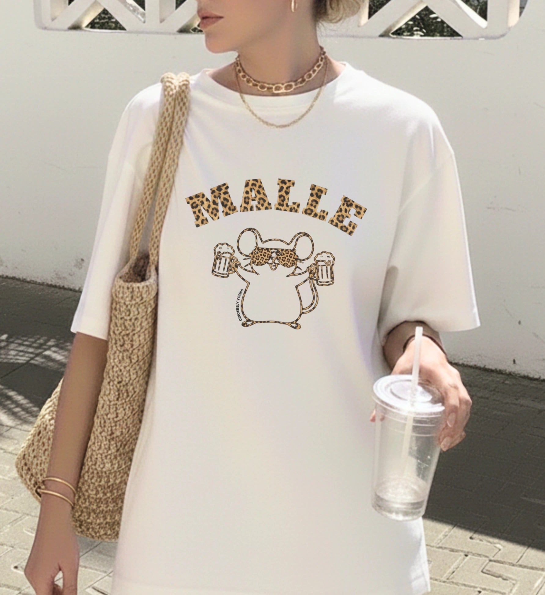 Frau trägt ein weißes Mallemaus T-Shirt von Cincerely Yours mit Leopard-Schriftzug Malle und einer Maus mit Sonnenbrille und Bierkrügen – ideales Party Shirt für Mallorca.