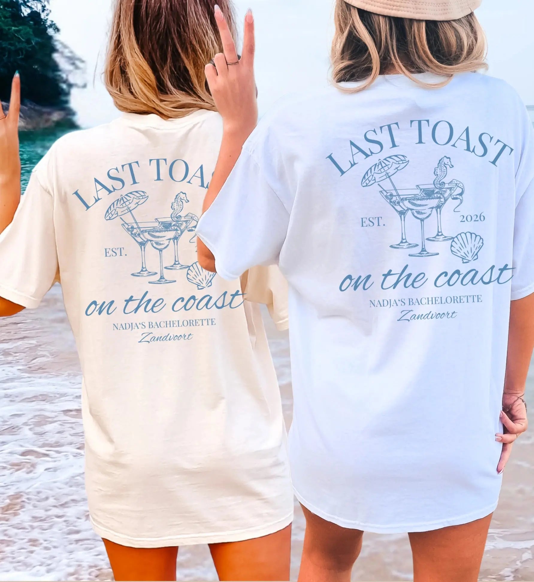 Zwei Frauen am Strand in oversized JGA T-Shirts mit blauem 'Last Toast on the Coast' Aufdruck, personalisierbar für Junggesellinnenabschiede am Meer.