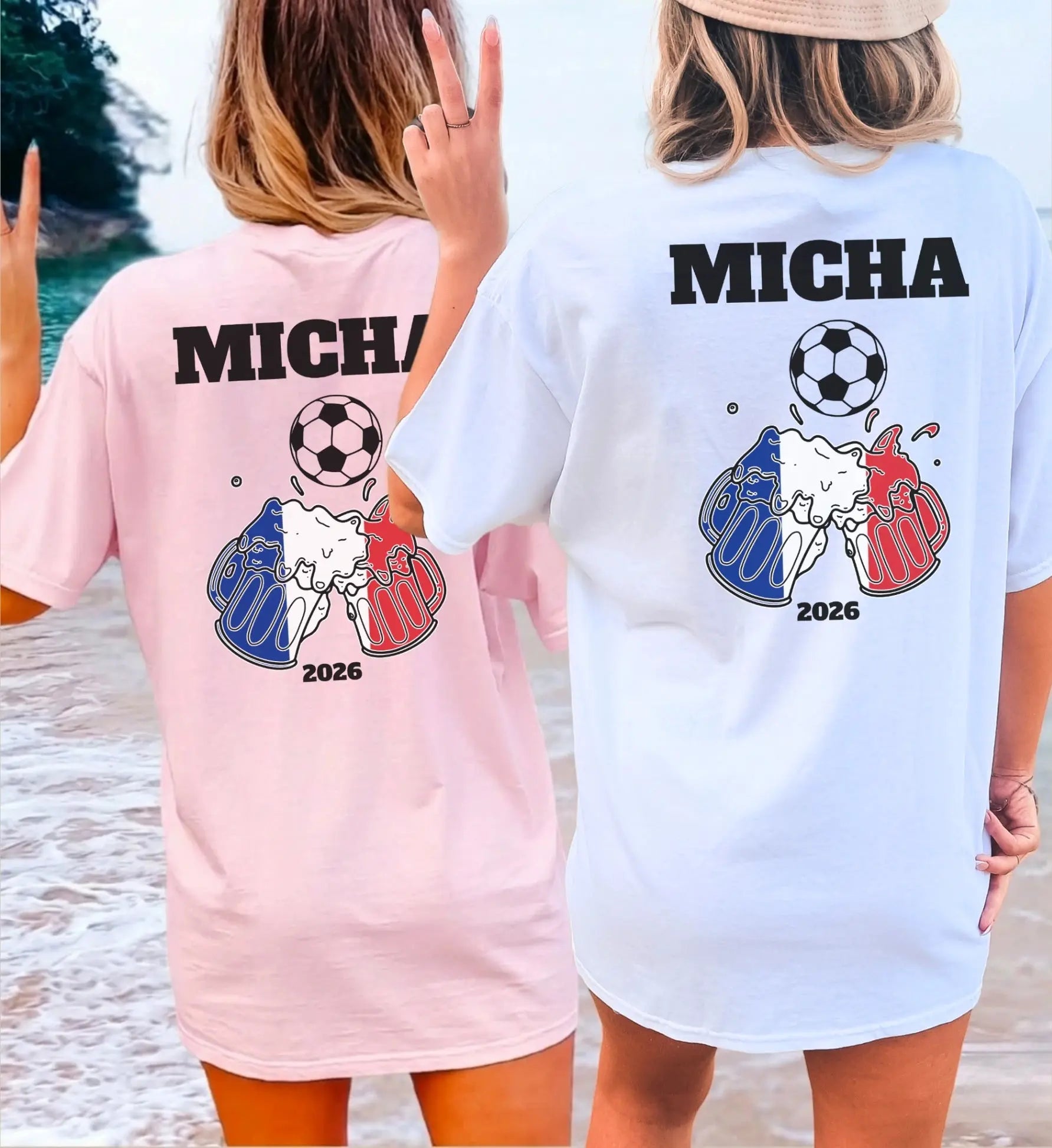 Zwei Frauen am Strand in personalisierten Fan-T-Shirts mit Fußball-Motiv, anstoßenden Bierkrügen in den Nationalfarben Frankreichs und individuellem Namen für den Urlaub 2026.