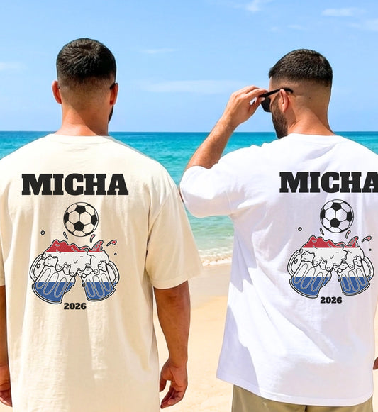 Zwei Männer am Strand in personalisierten Holland Fußball T-Shirts mit Micha-Namensaufdruck, Bierkrug-Illustration in niederländischen Nationalfarben und Fußball-Motiv für den Malle Urlaub 2026.
