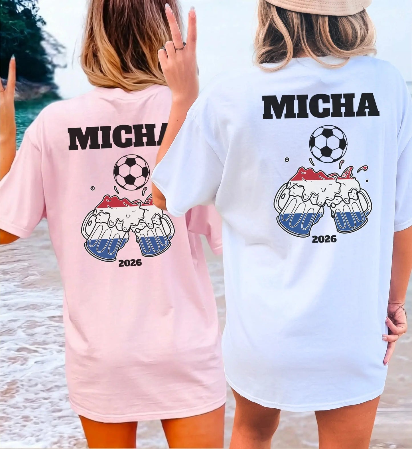 Zwei Frauen am Strand in personalisierten rosa und weißen T-Shirts mit Niederlande-Motiv, Fußball, Bierkrügen und dem Namen Micha für den Urlaub 2026.