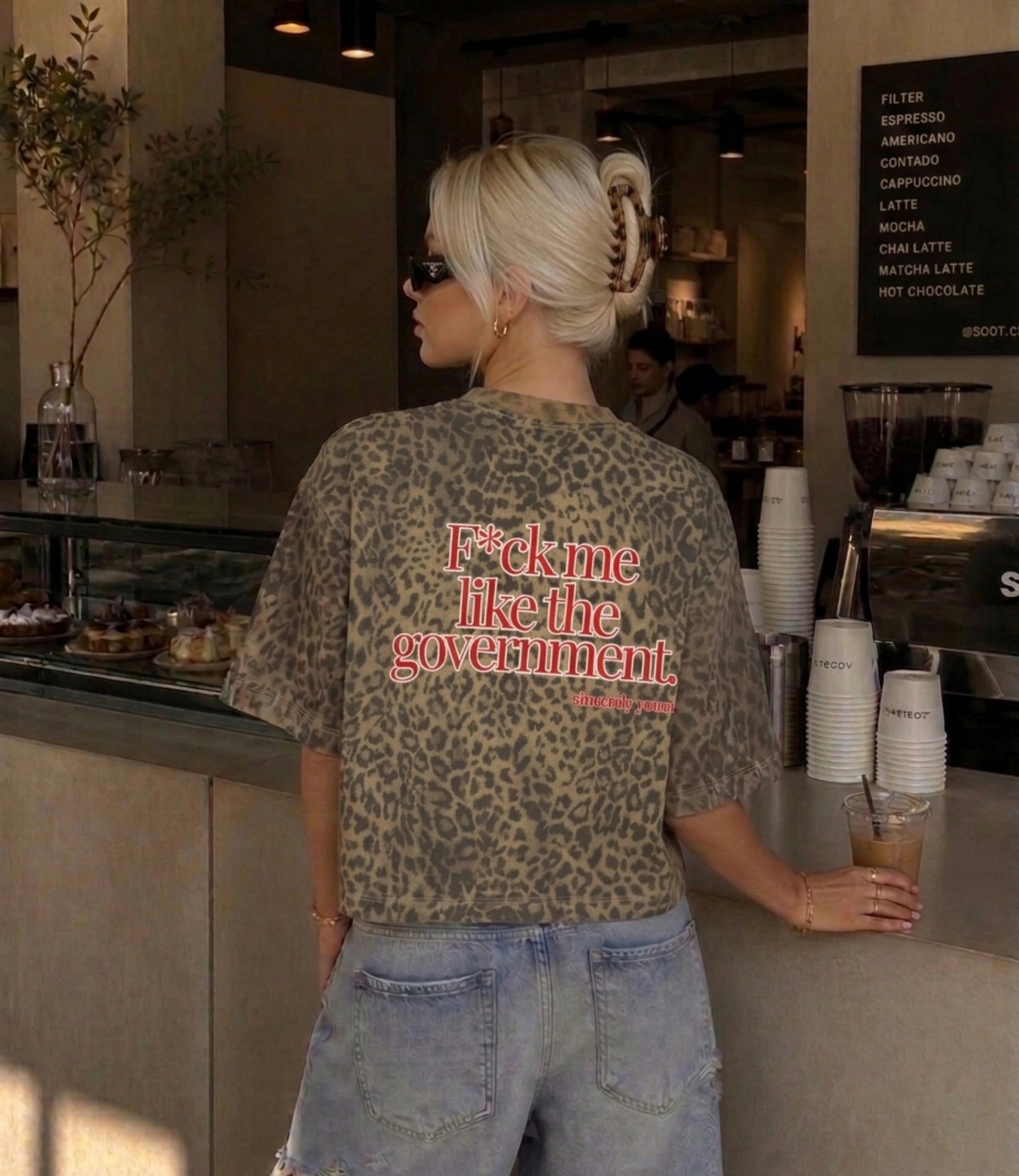 Ein stylisches Unisex Leopard Print T-Shirt von Cincerely Yours mit politischem Protest Spruch getragen in einem modernen Streetwear Lifestyle Outfit Kontext.