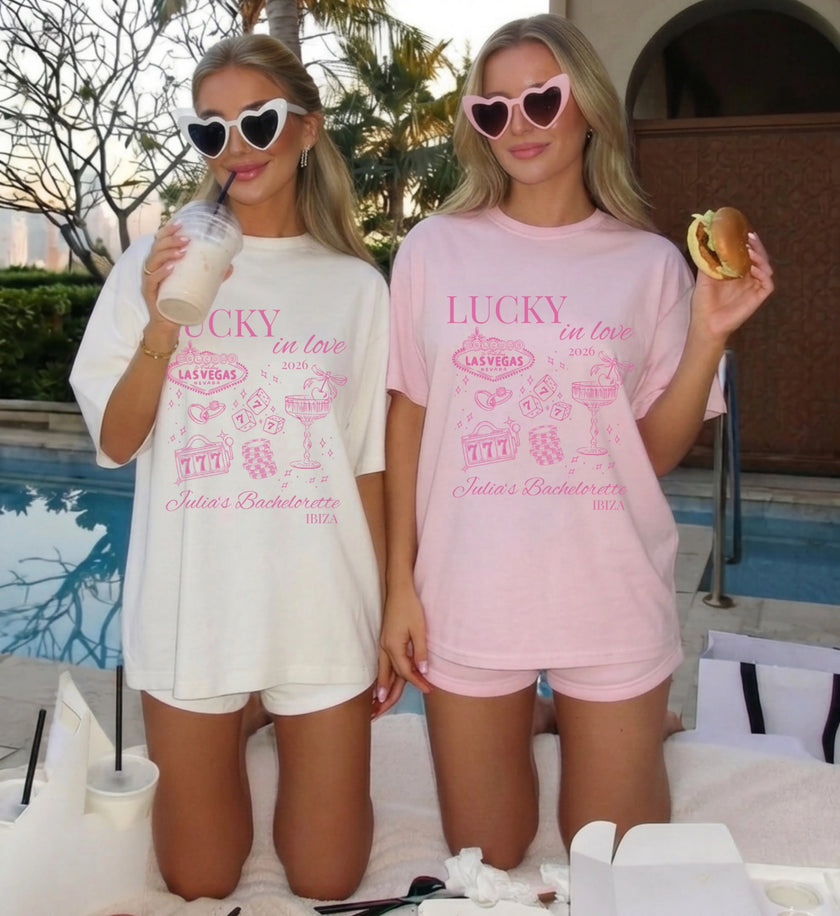 Nahaufnahme des pinken Vintage Casino Aufdrucks mit einer Retro Slot Machine und dem Slogan Lucky in Love für Las Vegas Bachelorette Partys.