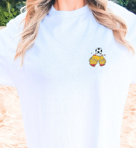 Weißes T-Shirt mit kleinem Brust-Print: Zwei anstoßende Bierkrüge in spanischen Flaggenfarben und ein Fußball, ideal für Mallorca-Urlaub und Fußballfans.